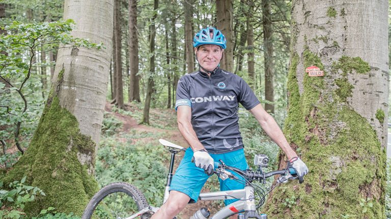 Der Mountainbiker Klaus Marbe auf seinem Fahrrad im Wald des Vogelsberges - Gründer einer Mountainbikeschule