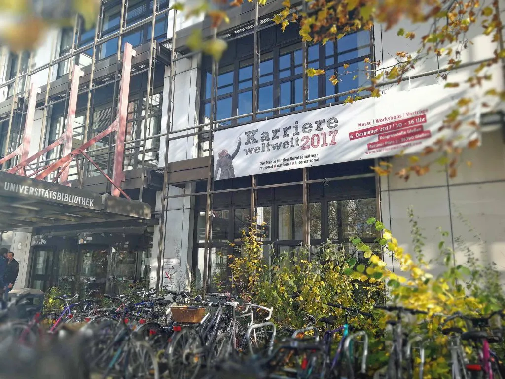 Mit Plakaten (so wie hier an der Universitätsbibliothek), Flyern und weiteren Ankündigungen laden JLU und THM zur gemeinsamen Messe „Karriere weltweit 2017“ am 6. Dezember 2017 ein. Foto: Benjamin Frank-Morgan.